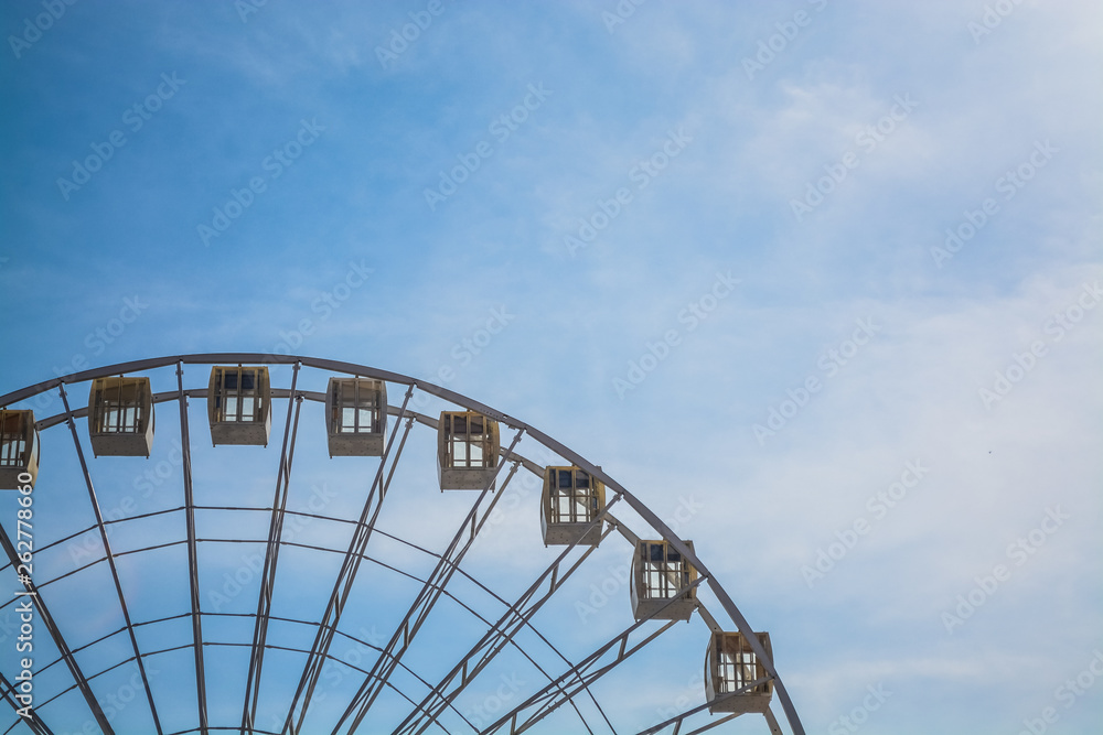 Big wheel against the background of the blue sky and an old city architecture Kiev, Ukraine. Amusement park. Area.