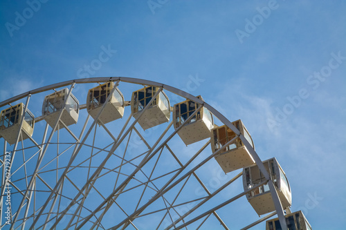 Big wheel against the background of the blue sky and an old city architecture Kiev, Ukraine. Amusement park. Area.