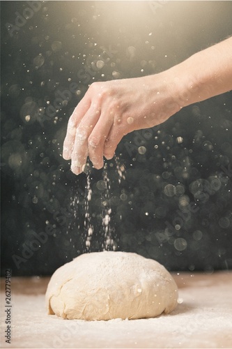 Woman's hands knead the dough close up