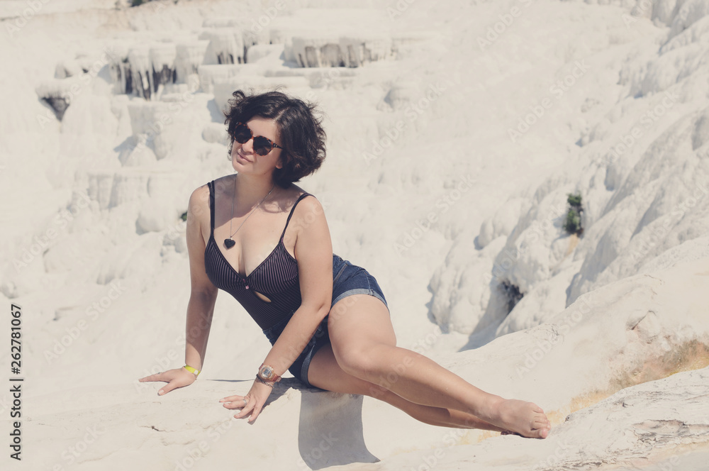 Fototapeta premium Beautiful girl sunbathes on the shore. Relaxation. Vacation. Artistic noise