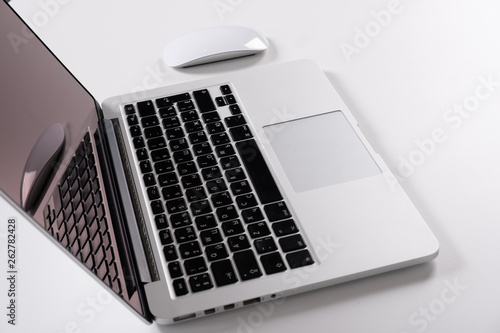 Laptop on a light table with a mouse and a telephone