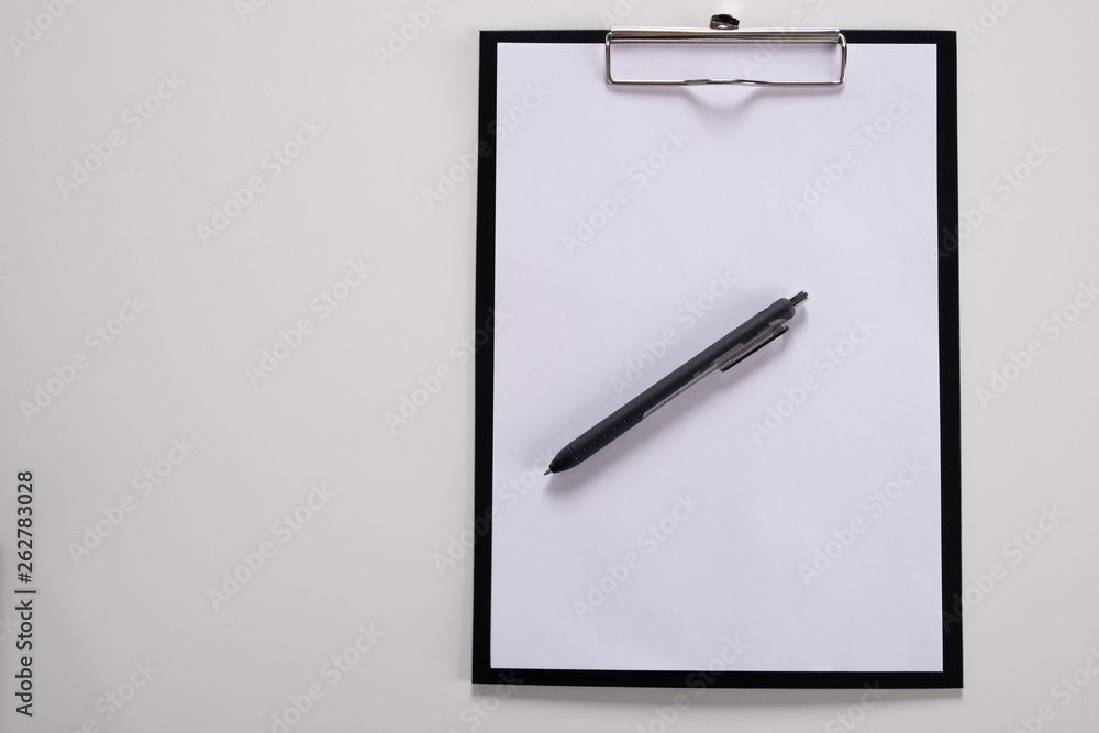 Tablet with writing paper with pen on white table Tablet with writing paper with pen on white table
