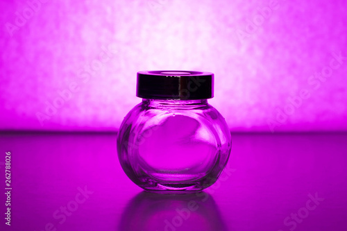Empty glass jar on a purple background