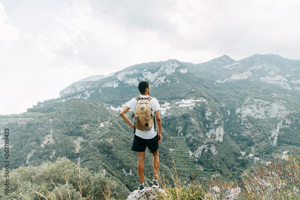 Mountain view in Italy, Amalfi. The traveler stands on a mountain with a backpack, travel blogger.