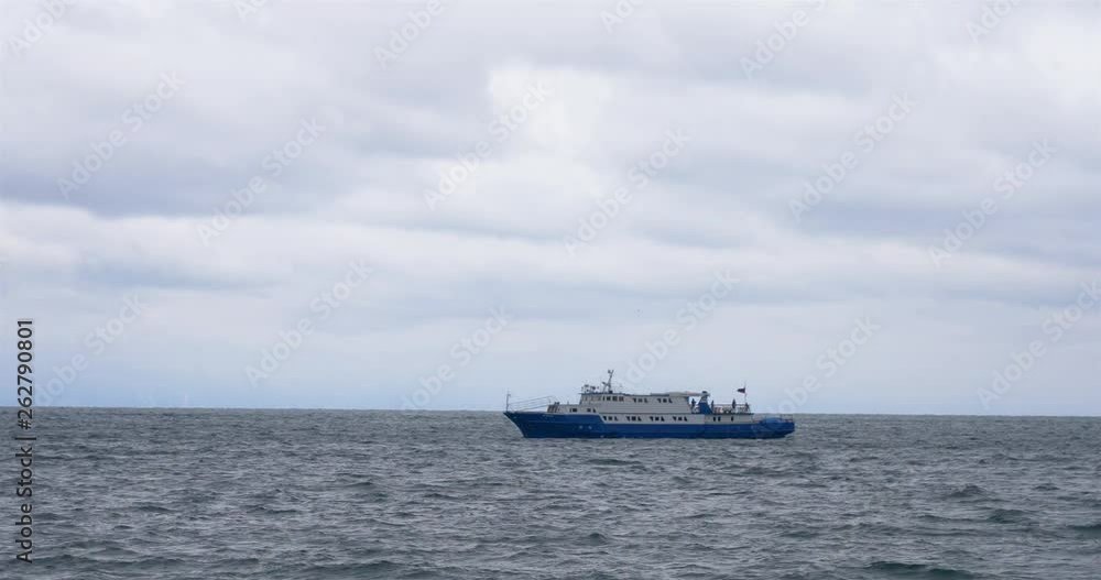 Glum cloudy sky Baikal lake wave and ship surfing on the water in Listvyanka, Russia Glum cloudy sky Baikal lake wave and ship surfing on the water in Listvyanka, Russia