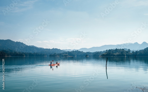 Mother and son floating on kayak together on calm water of Cheow Lan lake in Thailand © Soloviova Liudmyla