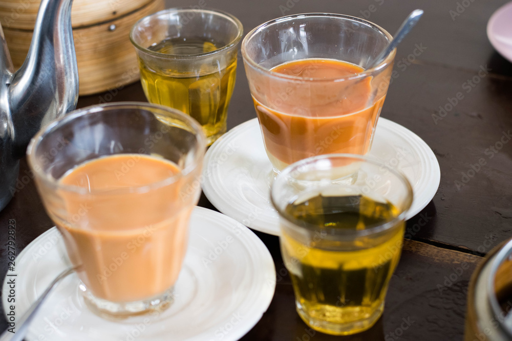 Thai tradition hot tea with sweetened condensed milk in old style cup (Selective focus) Thai tradition hot tea with sweetened condensed milk in old style cup (Selective focus)