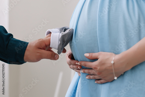 pregnant woman belly in a blue dress
