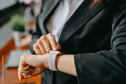 Cropped shot businesswoman checking time on smartwatch.