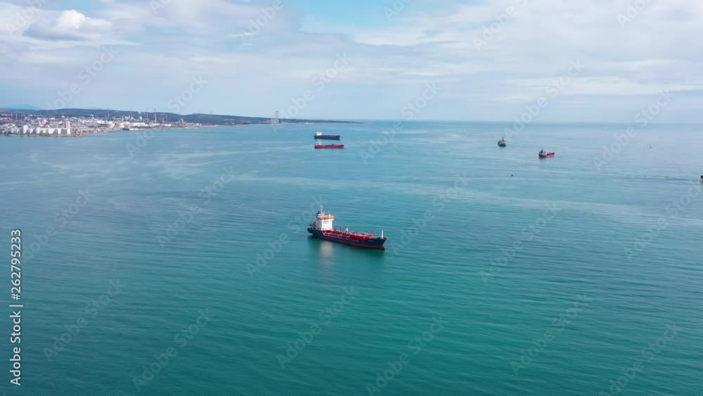Flying towards a fleet of oil tankers mediterranean shore France sunny day aerial Flying towards a fleet of oil tankers mediterranean shore France sunny day aerial