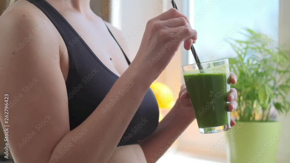 Woman drinking green detox smoothie Woman drinking green detox smoothie