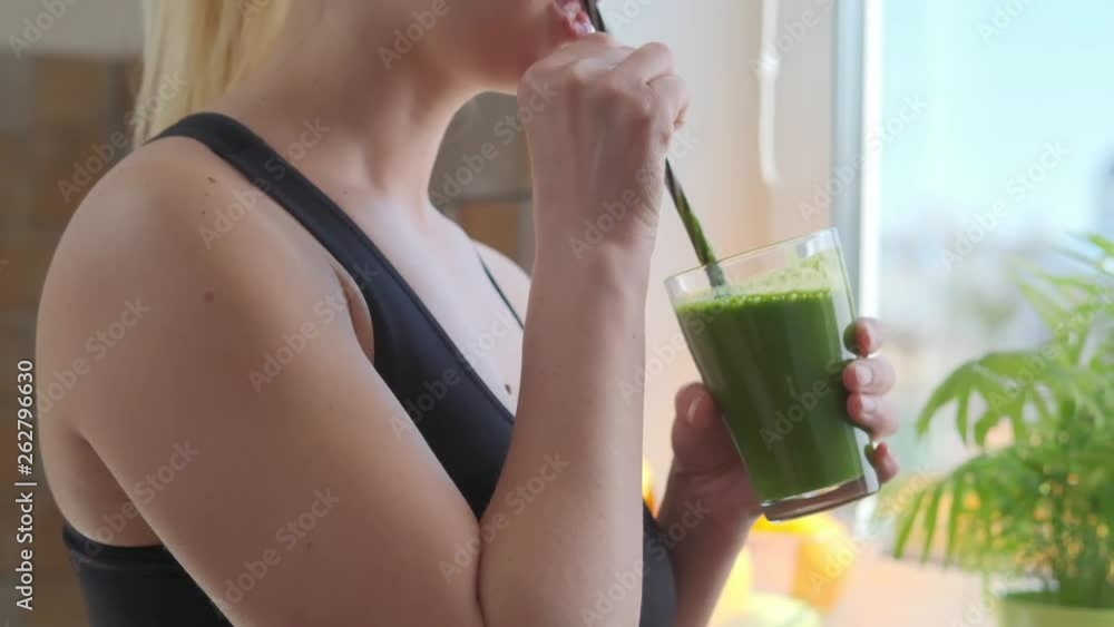 Woman drinking green detox smoothie Woman drinking green detox smoothie