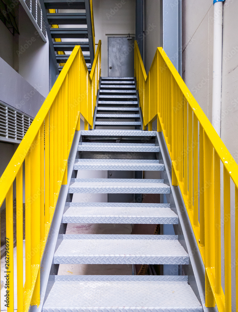 Fototapeta premium Metal fire escape with the yellow ladder.