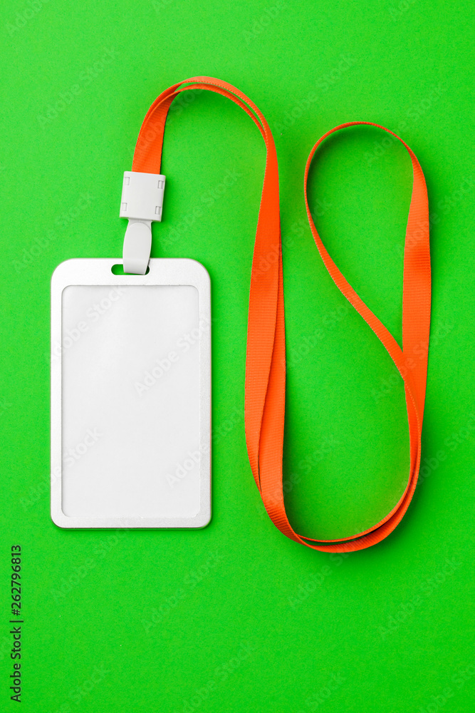 Fototapeta premium Blank security tag with a red stripe neck on a green background. Place for text, layout