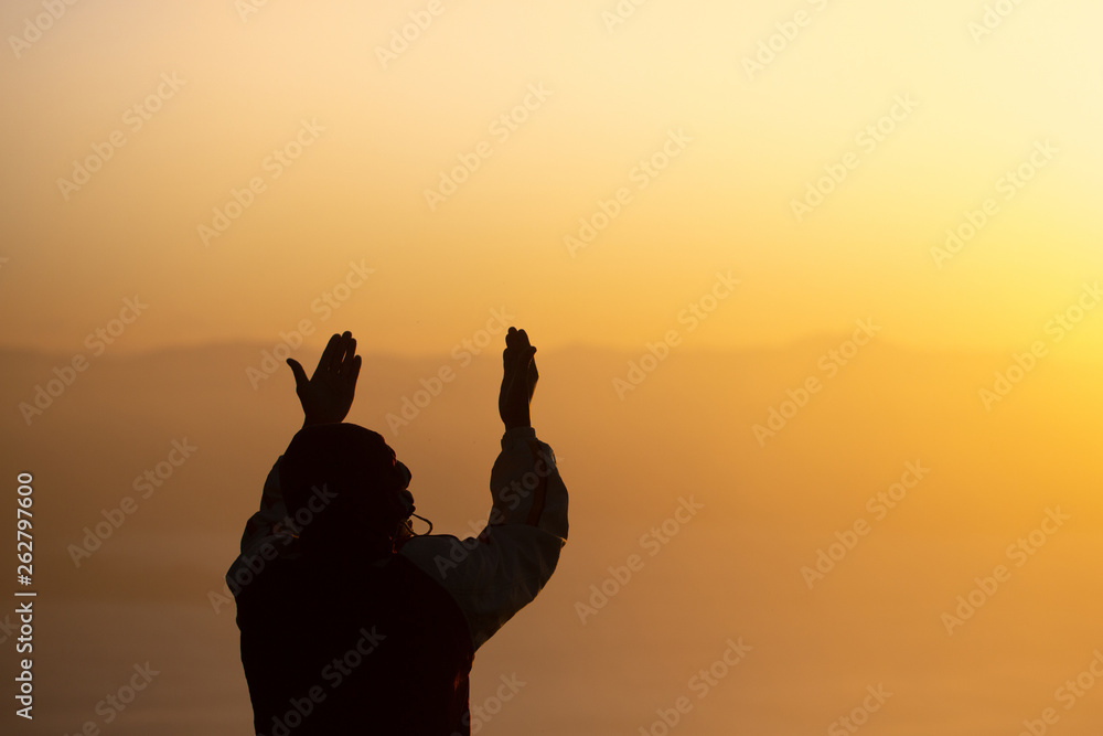 Young man praying in the morning, Hands folded in prayer concept for faith, spirituality and religion