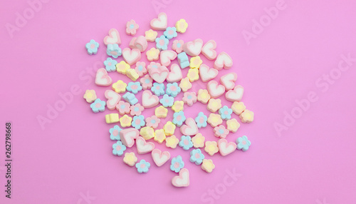 Flatlay colorful marshmallows on sweet pink background with copy space