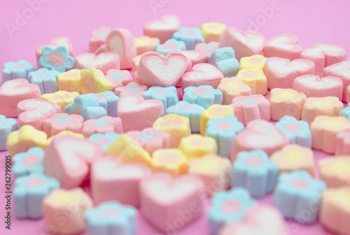 Closeup with selective focus colorful fluffy marshmallows on pink background