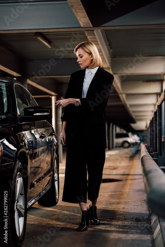 attractive blonde woman standing near black automobile in parking © LIGHTFIELD STUDIOS