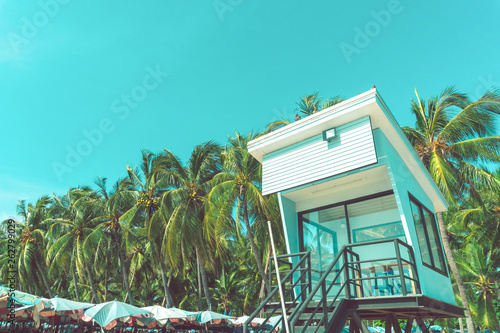 Beach sunrise with lifeguard tower and coastline with colorful cloud and blue sky.