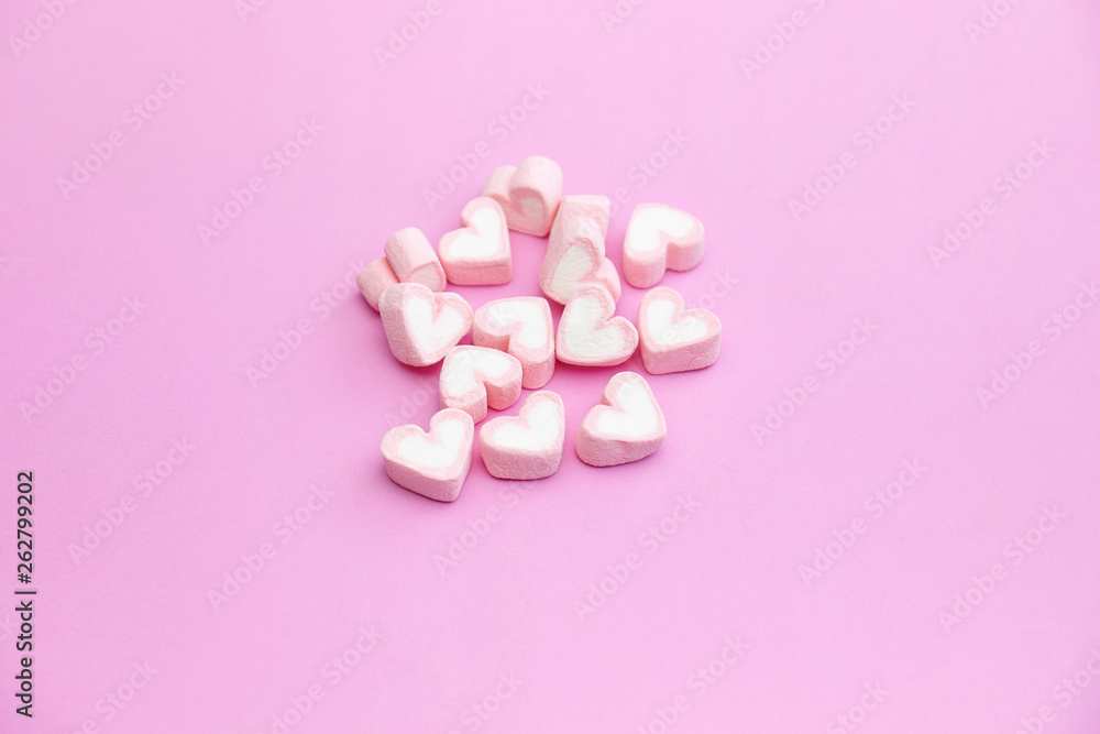 Top view flat lay design of pastel pink color marshmallows on pink background with copy space