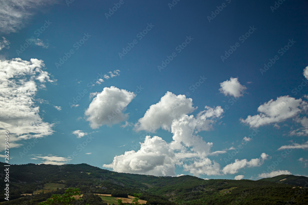 Panoramic view of a landscape with large cumulus cloud formations.