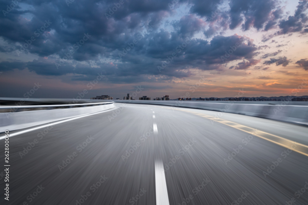 Fototapeta premium Motion-blurred highway in dusk clouds