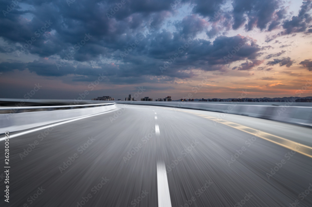 Motion-blurred highway in dusk clouds