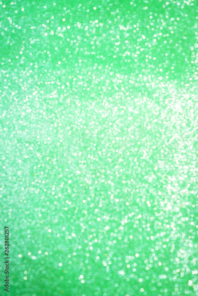 Blurred bokeh light green party background, Christmas and New Year holidays background. Party concept. Festive holiday card bright backdrop. Defocused. Flat lay, top view, copy space.