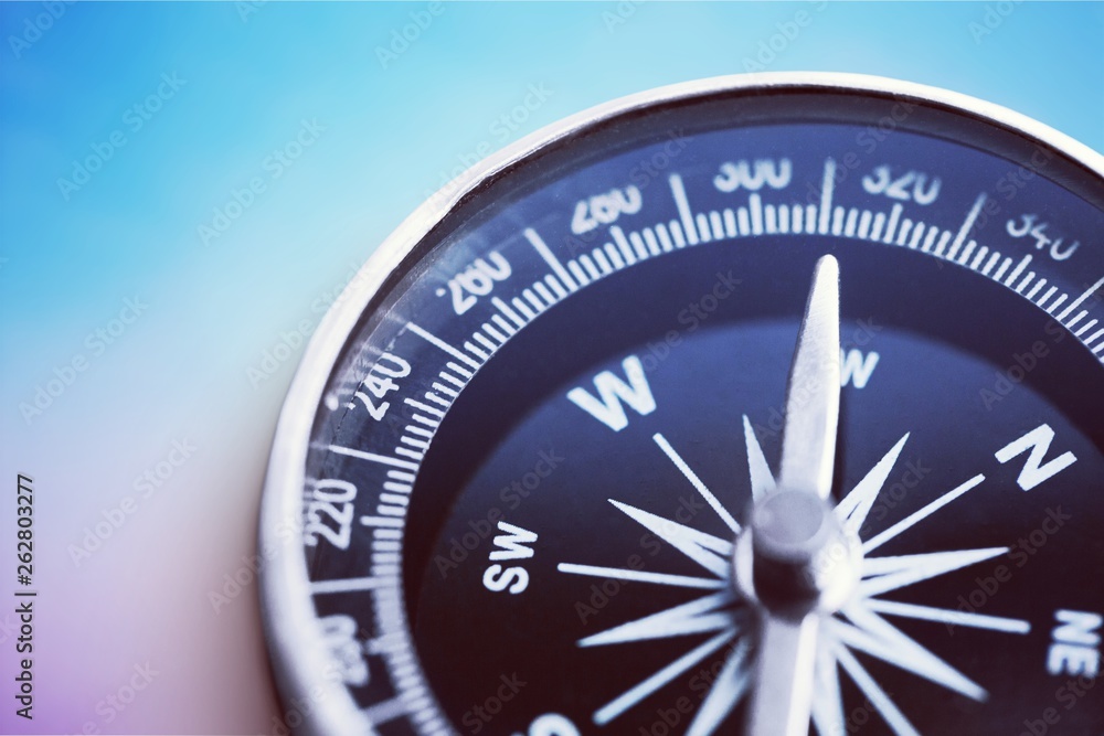 Brass antique compass on blue background. Close-up compass. Brass antique compass on blue background. Close-up compass.
