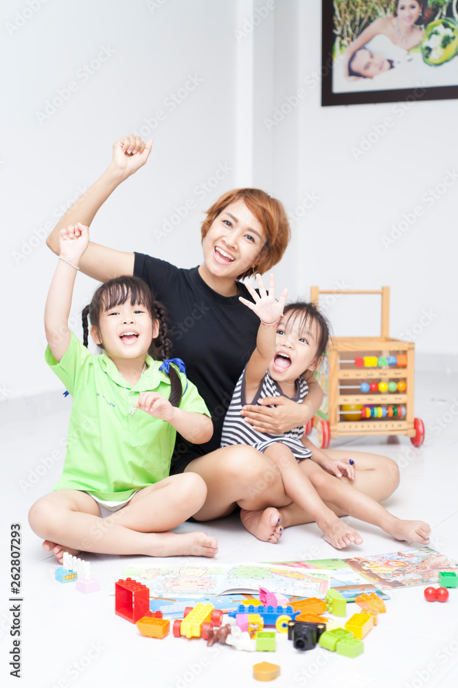 Fototapeta premium Mom is reading comic book with her daughters