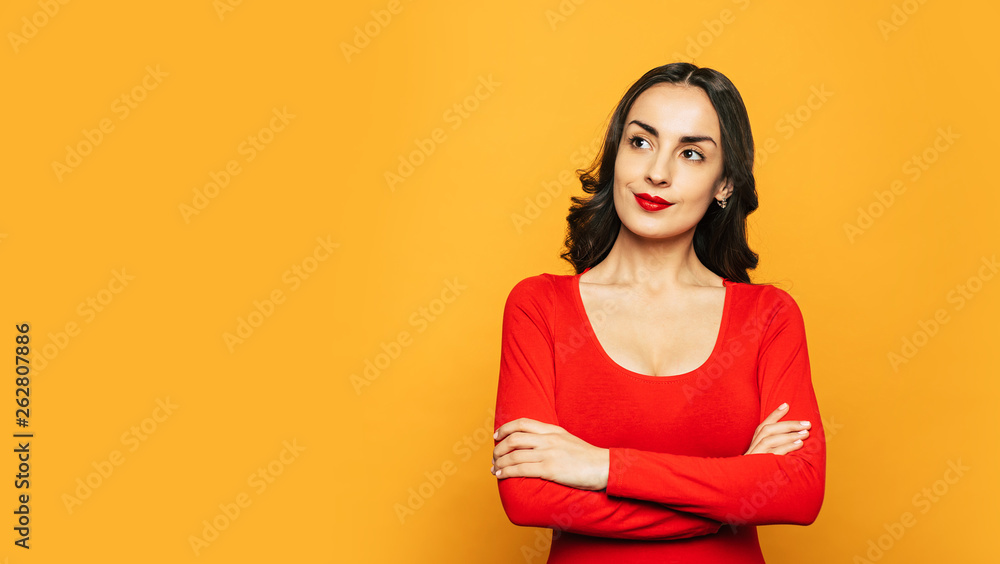 Obraz premium Cherry red. Fabulous girl with shiny wavy hair, tanned glowing skin and a red lilac lipstick on her full lips with matches her outfit.