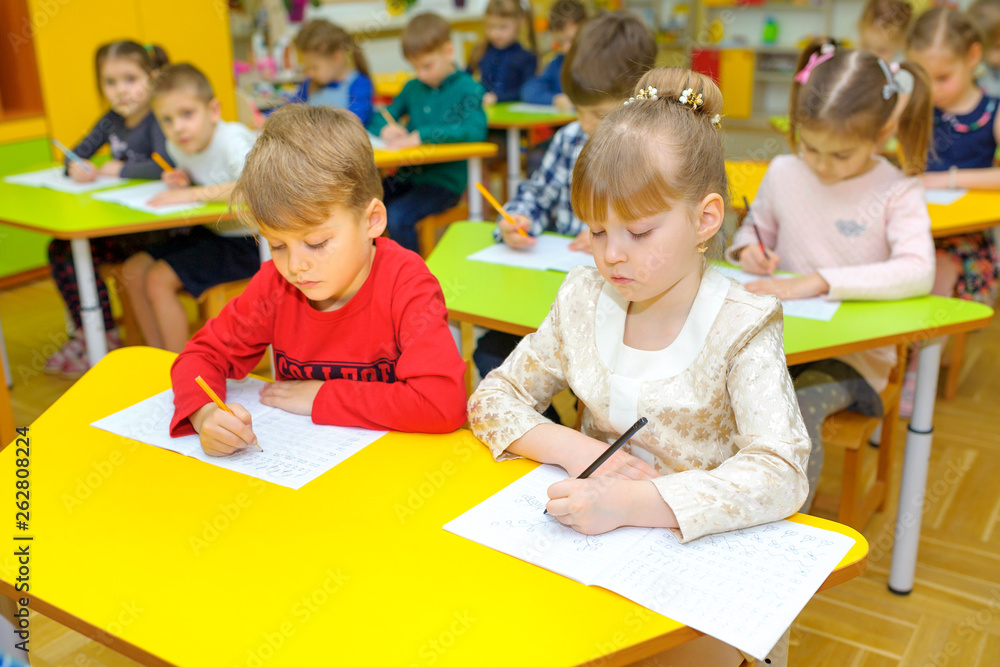 children at the desk in the classroom in kindergarten, the class learn to write children at the desk in the classroom in kindergarten, the class learn to write