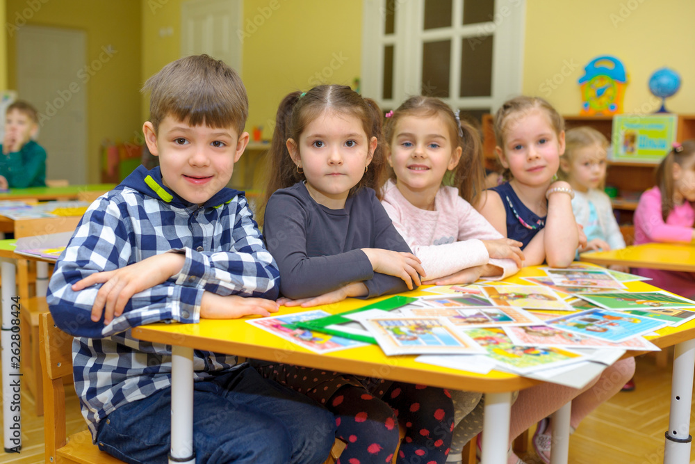 Fototapeta premium a group of children sit at the desk in a lesson in a kindergarten