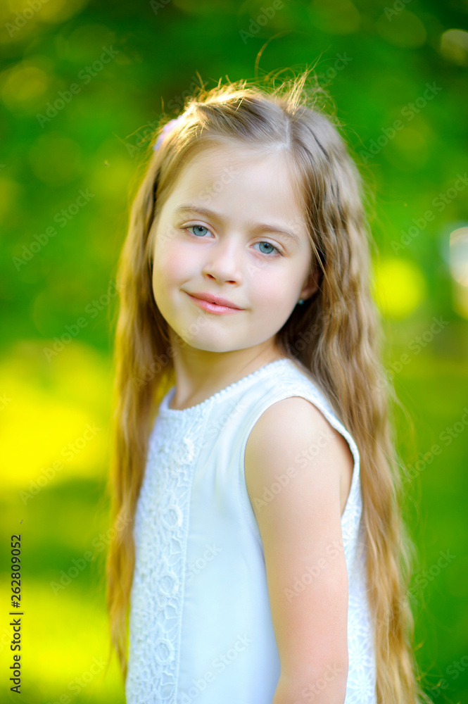 Portrait of cute happy young girl in beautiful evening park. five years old outdor. Smiling children. Blonde hair. summer park Portrait of cute happy young girl in beautiful evening park. five years old outdor. Smiling children. Blonde hair. summer park