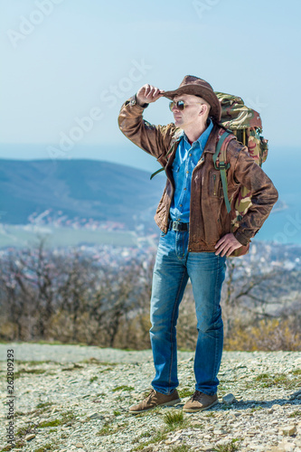 Adult male tourist in a hat with a backpack. Travel concept.