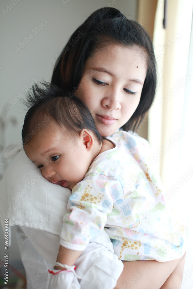 Mom is holding and kissing her baby with love Mom is holding and kissing her baby with love