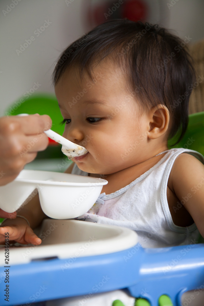 Mother is feeding baby in a house Mother is feeding baby in a house