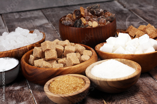 Various types of sugar, brown sugar and white on rustic wooden table