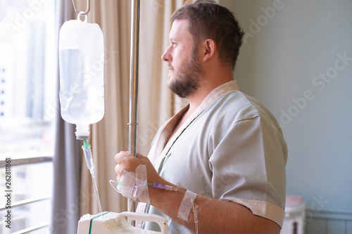 Wallpaper Mural patient with a dropper looks out the window of the hospital room and smiles. back view. Healthcare concept. Torontodigital.ca