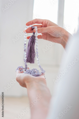 Woman hands holding lilac mala beads for meditation photo