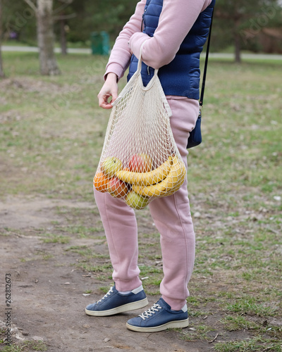 Young Woman Holding Reusable String Shopping Grocery Eco Bag with fruits