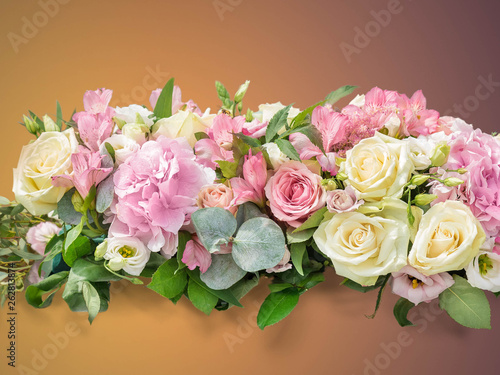 Flowers Gentle art composition. A bouquet from branches an eucalyptus, a hydrangea, Alstroemeria, gentle roses on a brown gradient background