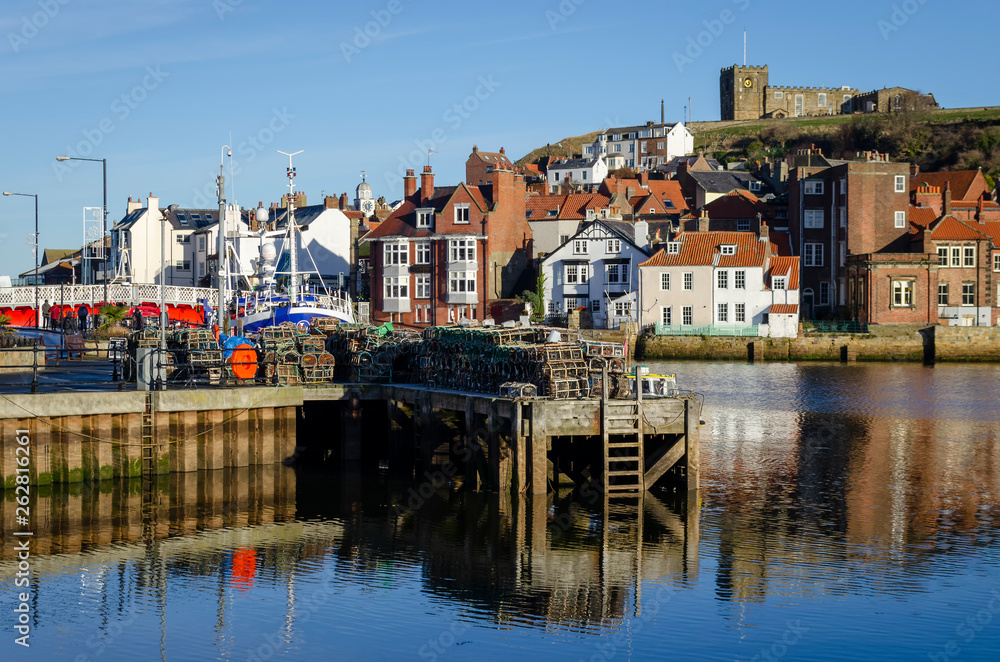 Whitby fishing harbour on the Yorkshire coast, on a clear afternoon showing some lobster pot on the quay side. 