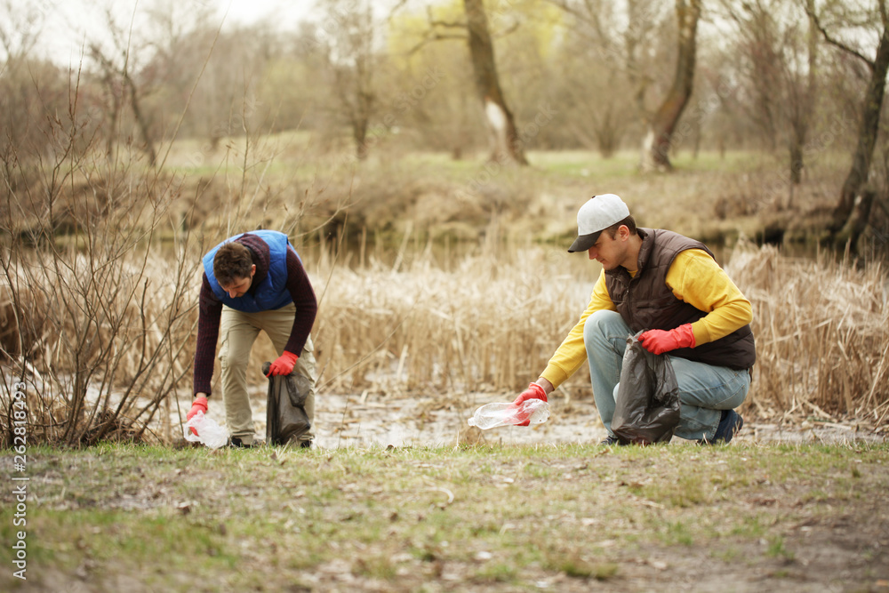 Charity volunteer picks up litter in forest, caring for nature. Spring cleaning in park, outdoor trash and rubbish. Charity volunteer picks up litter in forest, caring for nature. Spring cleaning in park, outdoor trash and rubbish.