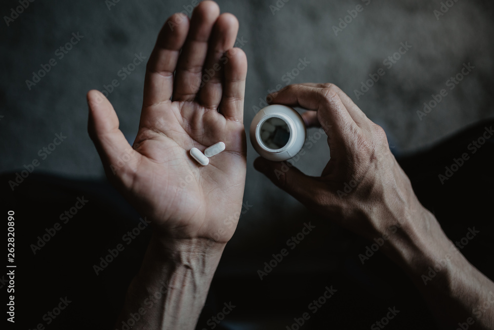 Fototapeta premium Man holding the pills