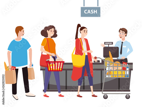Cashier behind the cashier counter in the supermarket, shop, store serves the buyer, a womans with a basket and grocery cart full of groceries