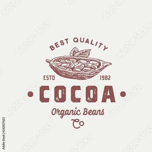 Organic Cocoa Beans Abstract Vector Sign, Symbol or Logo Template. Hand Drawn Sketch Cacao Bean Sillhouette with Leaves and Retro Typography. Vintage Weathered Emblem.
