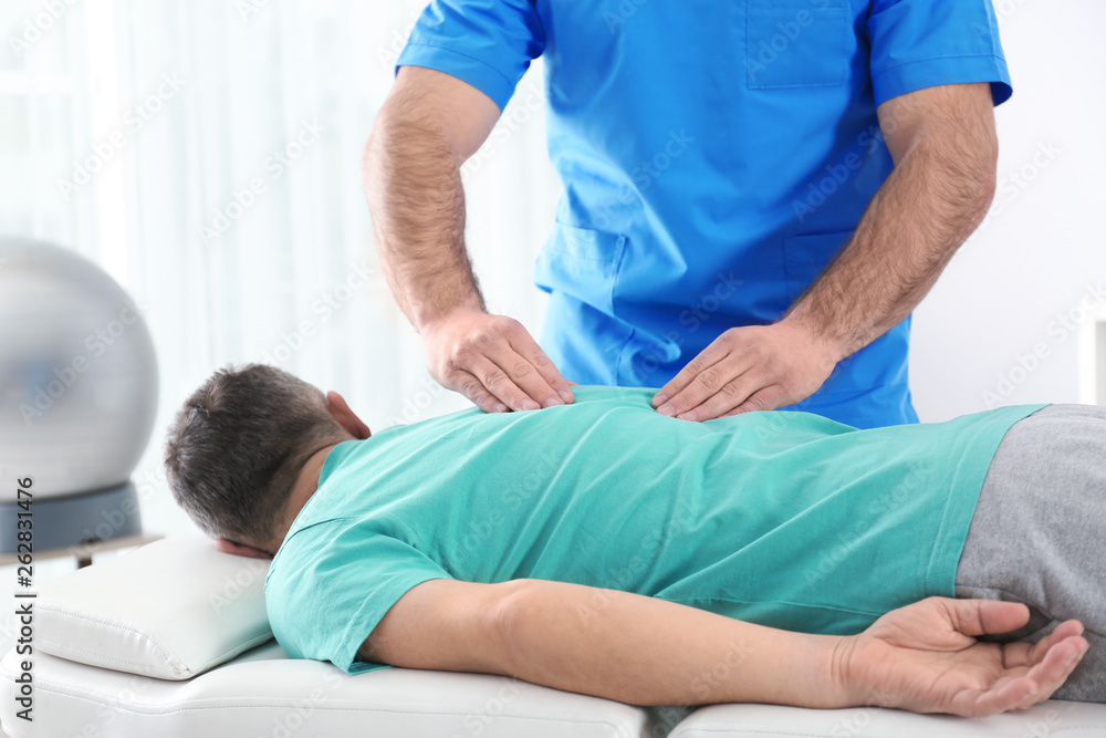 Fototapeta premium Doctor working with patient in hospital. Rehabilitation massage