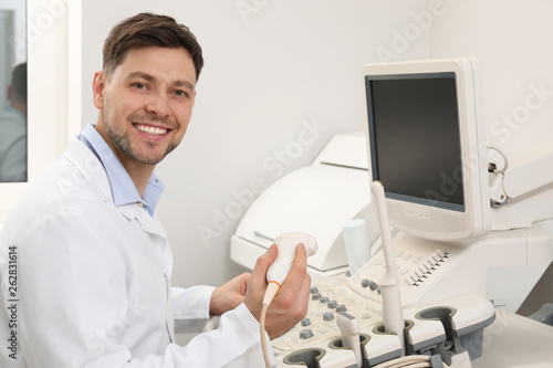 Sonographer operating modern ultrasound machine in clinic