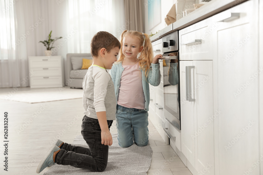 Little kids waiting for preparation of food in oven at home Little kids waiting for preparation of food in oven at home
